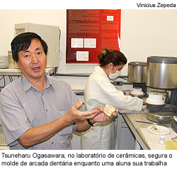 Tsuneharu Ogasawara, no laboratório de cerâmicas, segura o molde de arcada dentária enquanto uma de suas alunas trabalha